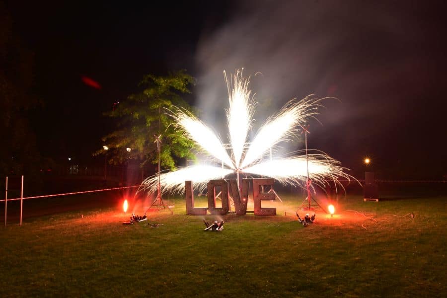 Ein Feuerwerksfächer vor einem LOVE Schriftzug